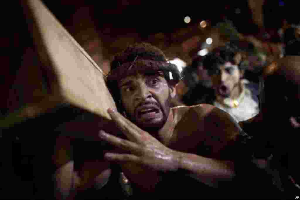 A man participates in a reenactment of the Passion of Jesus Christ on Good Friday during Holy Week celebrations at Rocinha slum in Rio de Janeiro, Brazil, Friday April 6, 2012. Holy Week commemorates the last week of the life of Jesus, culminating in his