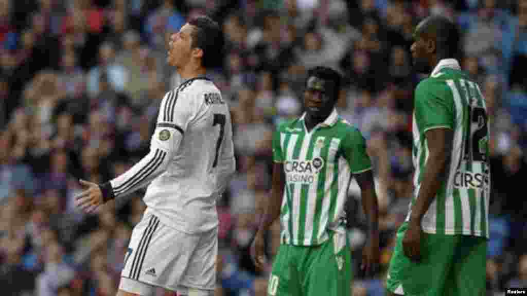 Real Madrid's Cristiano Ronaldo from Portugal, left, gestures beside Betis' Nosa Igiebor from Nigeria, center, during a Spanish La Liga football match, Saturday April 20, 2013.