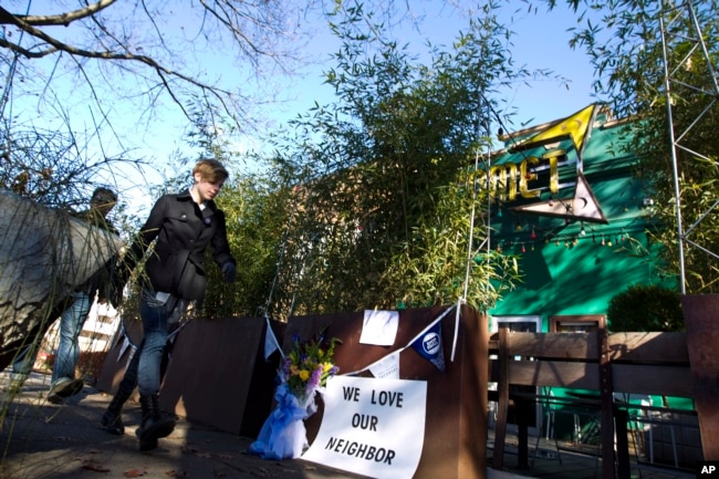 FILE - Pedestrians pass by the front door of Comet Ping Pong pizza shop, in Washington, Dec. 5, 2016. A fake news story prompted a man to fire a rifle inside the popular eatery as he attempted to "self-investigate" a conspiracy theory of a child sex trafficking ring.