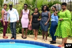 Uganda's Minister for Tourism Godfrey Kiwanda (2-L) poses next to participants during the launch of the Miss Curvy beauty contest in capital Kampala, Feb. 5, 2019.