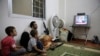 Free Syrian Army fighter watches U.S. President Barack Obama's speech with his family in Ghouta, Damascus, Aug. 31, 2013.