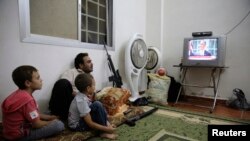 시리아인들이 바락 오바마 대통령의 시리아 관련 성명 발표 현장을 TV로 시청하고 있다.
