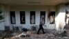 A policeman walks past a damaged window after riots following the announcement of last month's presidential election results at the Election Supervisory Agency (Bawaslu) headquarters in Jakarta, Indonesia, May 23, 2019. 