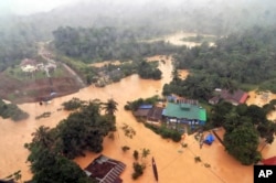 Flooding has displaced more than 100,000 in Malaysia, with high waters leaving roads impassable in its national park in Kuala Tahan, Pahang, shown Dec. 24, 2014.