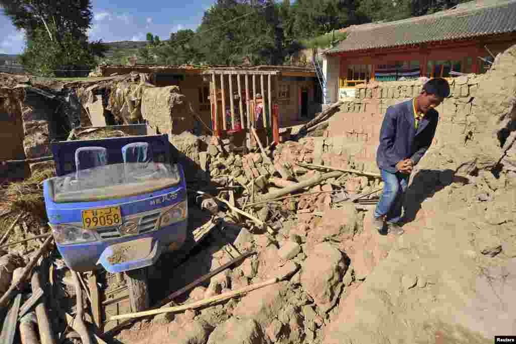 A man walks past a collapsed house after a 6.6 magnitude earthquake in Minxian county, Dingxi, Gansu province, July 22, 2013.