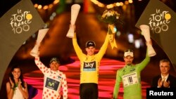 Pebalap sepeda Inggris dari Team Sky, Christopher Froome (tengah) saat menerima trophy sebagai juara Tour de France ke-100 tahun ini Minggu di Paris (21/7). (Reuters/Bernard Papon) 