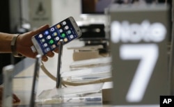 FILE -A customer holds a Samsung Electronics Galaxy Note 7 smartphone at the headquarters of South Korean mobile carrier KT in Seoul, South Korea, Friday, Sept. 2, 2016.