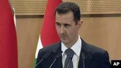 In this screen capture from Syrian TV, Syria's President Bashar Assad delivers a speech in Damascus, June 20, 2011