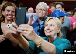 U.S. Democratic presidential nominee Hillary Clinton takes a selfie with supporters following a rally at Lincoln High School in Des Moines, Iowa, Aug. 10, 2016.