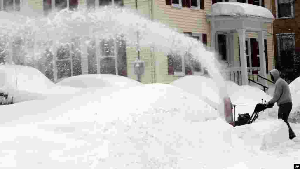 Un homme enlève la neige à Concord, NH, diamnche 16 février 2015.