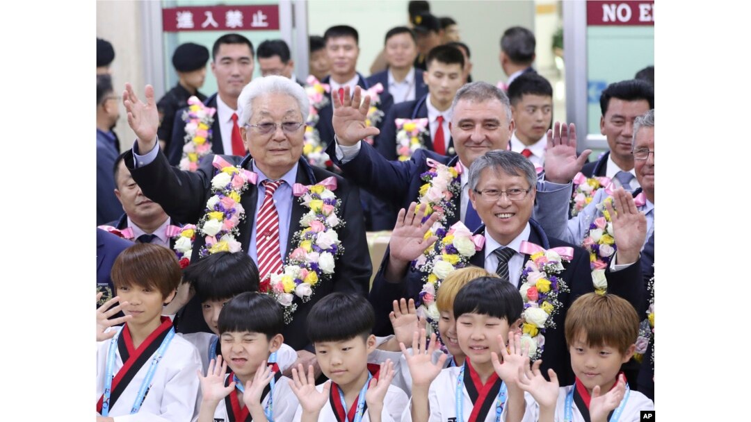 North Korea's IOC member Chang Ung, middle row left, waves with officials of International Taekwondo Federation upon their arrival at Gimpo International Airport in Seoul, South Korea, June 23, 2017.