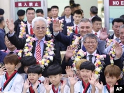 North Korea's IOC member Chang Ung, middle row left, waves with officials of International Taekwondo Federation upon their arrival at Gimpo International Airport in Seoul, South Korea, June 23, 2017.