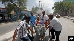 Sekouris kap pote yon nonm ki te blese nan yon atak ak bonm kote yon kòmando suisid te itilize yon machin pyeje pou l te touye plizyè moun nan Mogadisio, Somali Lendi 13 mas 2017 la. (Foto: AP/Farah Abdi Warsameh)