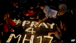 Mourners arrange candles to honor victims of the downed Malaysia Airlines Flight 17, at a shopping mall in Petaling, Jaya, near Kuala Lumpur, Malaysia, July 18, 2014. 