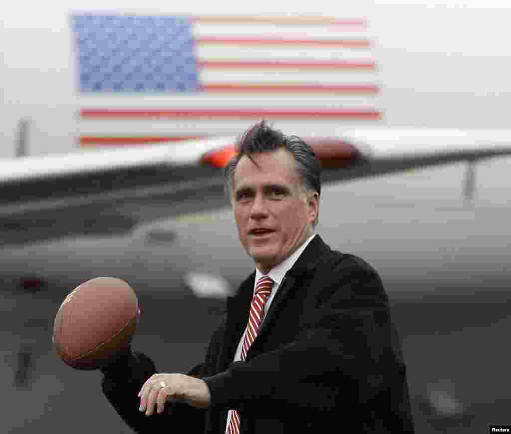 Republican presidential candidate and former Massachusetts Gov. Mitt Romney holds a football on the tarmac of Akron-Canton Regional Airport in Akron, Ohio, Oct. 26, 2012. 