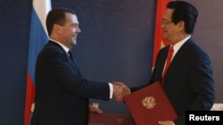 Tư liệu - Thủ tướng Nga ông Dmitry Medvedev bắt tay với người đồng cấp bên phía Việt Nam là ông Nguyễn Tấn Dũng tại Burbabai, Kazakhstan, ngày 29 tháng 05 năm 2015, sau khi Việt Nam kí thoả thuận hợp tác với khối EEU.