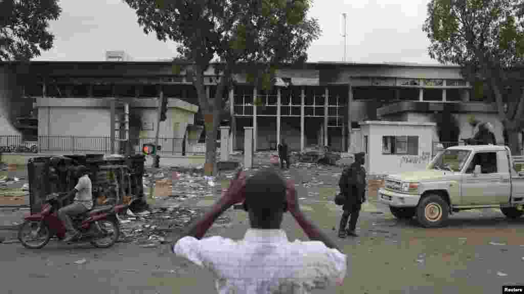 Un homme prend des photos de ce qui reste du parlement qui a été l&rsquo;objet des pillages et saccages jeudi 30 octobre 2014 lors des manifestations qui ont conduit au départ du président Blaise Compaoré du pouvoir après 27 ans de règne vendredi 31 octobre 2014. 