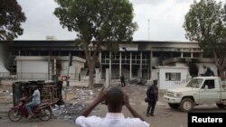 Un homme prend une photo de l'édifice du Parlement brûlé à Ouagadougou, capitale du Burkina Faso 31 octobre 2014.