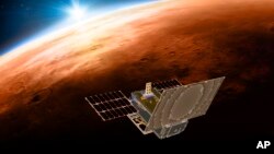 This illustration made available by NASA on March 29, 2018 shows the twin Mars Cube One (MarCO) spacecraft flying over Mars with Earth and the sun in the distance. The MarCOs will be the first CubeSats - a kind of modular, mini-satellite - flown into deep