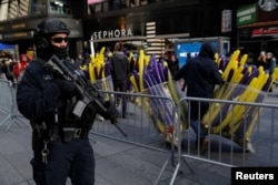 A member of the New York Police Department's Counterterrorism Bureau monitors security in Times Square ahead of New Year's celebrations in Manhattan, Dec. 29, 2017.