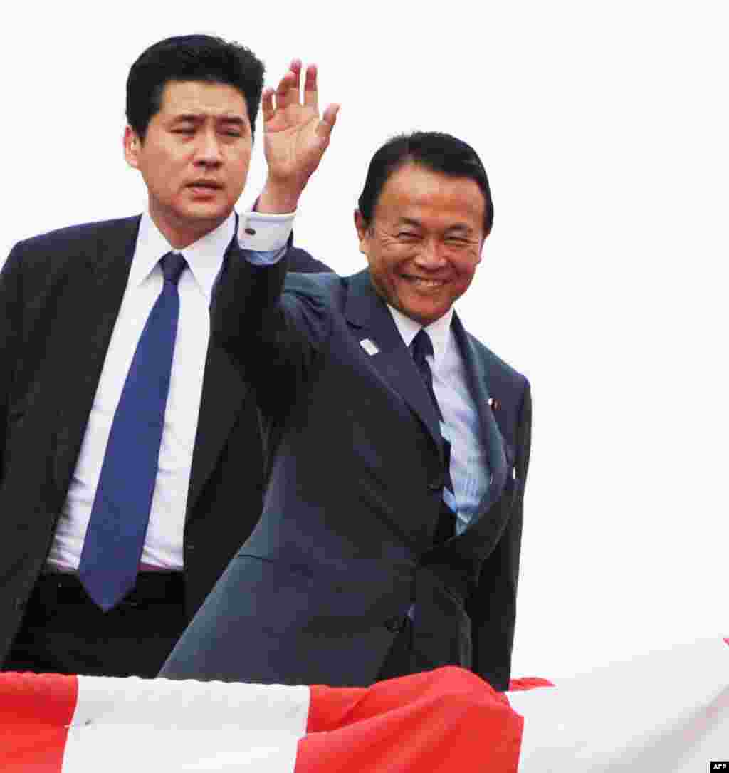 Japanese Finance and Deputy Prime Minister Taro Aso waves to guests while attending the launch ceremony for Japan&#39;s newest warship at the port in Yokohama, August 6, 2013. 