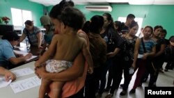Women and their children wait in line to register at the Honduran Center for Returned Migrants after being deported from Mexico. (File)