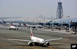An Emirates airline passenger jet taxis at Dubai International airport in Dubai, United Arab Emirates. Emirates said it is suspending flights to Qatar.