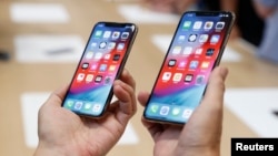 A man holds the newly released Apple iPhone XS and XS Max during a product demonstration following the Apple launch event at the Steve Jobs Theater in Cupertino, California, U.S. September 12, 2018. 