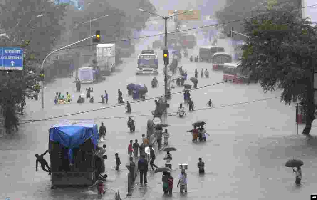 People walk through a flooded street following heavy monsoon rains in Mumbai, India.