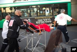 Israeli rescue personal evacuate a woman from a stabbing attack site in Rishon Lezion, Israel, Monday, Nov. 2, 2015.