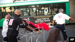 Israeli rescue personal evacuate a woman from a stabbing attack site in Rishon Lezion, Israel, Monday, Nov. 2, 2015. 