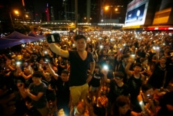Protesters turn on their mobile phone flashlights as they block an area outside the government headquarters building in Hong Kong Oct. 1, 2014.