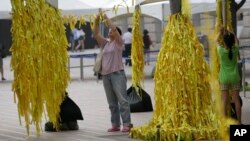 Người dân Hàn Quốc buộc những dải ruy băng màu vàng với những thông điệp cho nạn nhân trên chiếc phà Sewol bị chìm, ngày 28/7/2014.