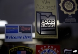 FILE - A supermarket displays stickers indicating it accepts food stamps in West New York, N.J., Jan. 12, 2015.