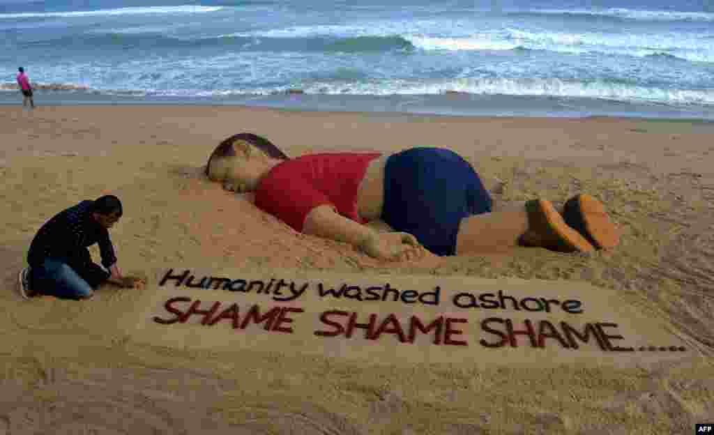 Indian artist Sudarsan Pattnaik works on a sand sculpture depicting drowned Syrian boy Aylan Kurdi, 3, at Puri beach, some 65 kilometers away from Bhubaneswar. Photos of the child's lifeless body, lying on a beach in Bodrum, Turkey, have triggered a wave of emotion across the continent, despite deep divisions among European governments on how to deal with the crisis.