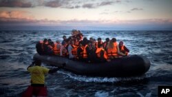 Des réfugiés et migrants arrivent sur un canot à l'île grecque de Lesbos après avoir traversé la mer Egée de la côte turque, 18 décembre 2015. 