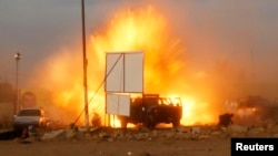 An explosion is seen during a car bomb attack at a Shi'ite political organization's rally in Baghdad, Iraq, April 25, 2014.