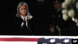 La representante Debbie Dingell, D-Mich. se encuentra en el ataúd de su esposo y el exrepresentante John Dingell, quien descansa en Dearborn, Michigan.