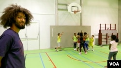 Volunteer Nabil Fallah from Molenbeek offers basketball training to young kids from his neighborhood in Brussels, Belgium, September 2016. (M. van der Wolf/VOA)