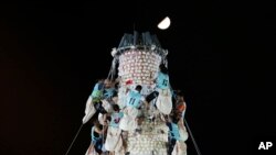 Participants climb up the bun tower during the bun snatching competition on the outlying Cheung Chau island in Hong Kong, Bun Festival. 