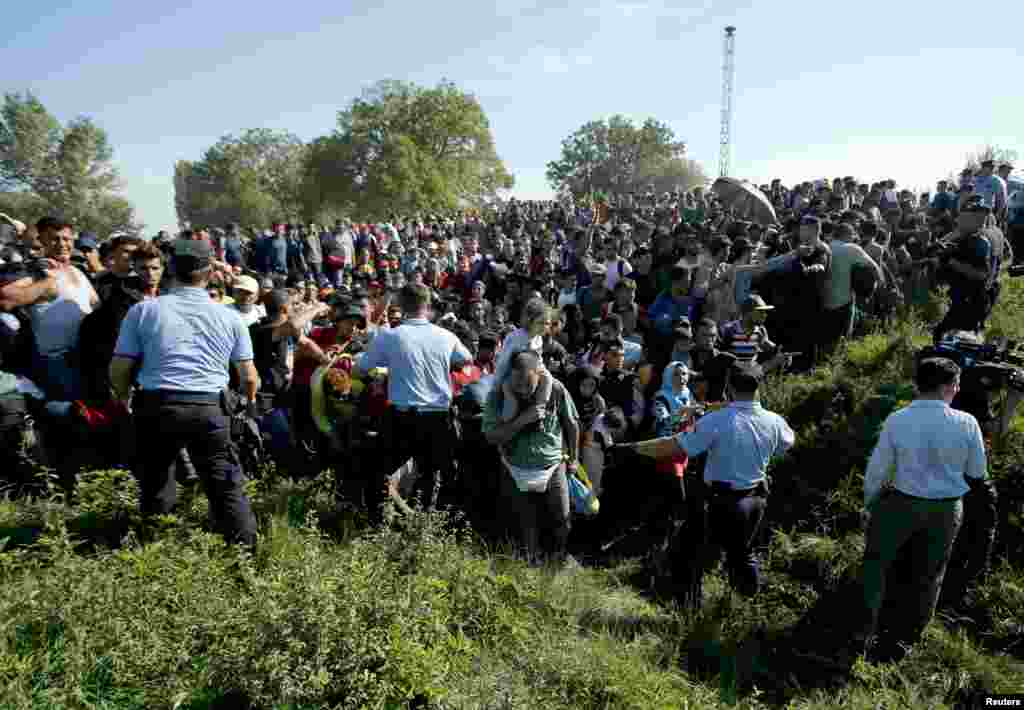 Police direct migrants during a stampede to board a bus in Tovarnik, Croatia, Sept. 17, 2015. Croatia said it could not take in any more migrants, amid chaotic scenes of riot police trying to control thousands who have streamed into the European Union country from Serbia.