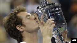 El británico Andy Murray besa el trofeo ganado anoche en el Abierto de Estados Unidos, en Nueva York, su primer Grand Slam.