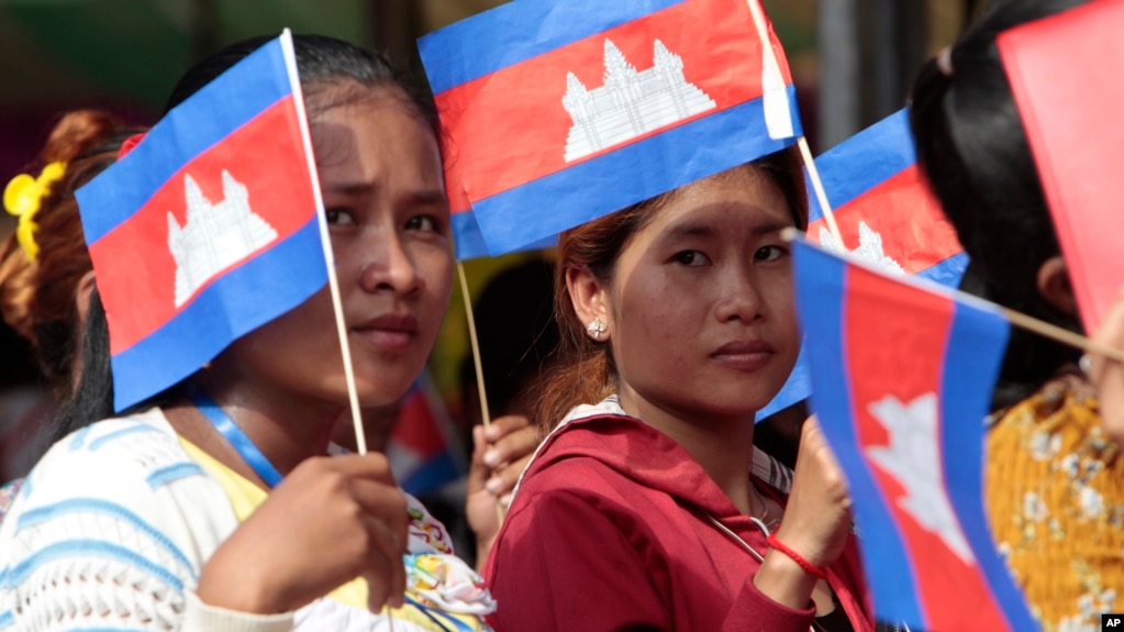 Garment workers welcome Prime Minister Hun Sen outside of Phnom Penh, Cambodia, Wednesday, Aug. 30, 2017. Hun Sen is on a country-wide trip to visit the nation's factory workers to hear their hopes and concerns in person. (AP Photo/Heng Sinith)