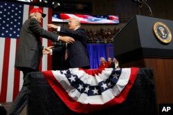 President Donald Trump gets ready to embrace U.S. Senate candidate Luther Strange during a campaign rally, in Huntsville, Alabama, Sept. 22, 2017.
