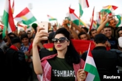 A Kurdish woman takes a selfie to show support for the upcoming September 25th independence referendum in Irbil, Iraq Sept. 22, 2017.