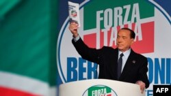 Former Italian prime minister Silvio Berlusconi holds a campaign booklet as he addresses a rally of right-wing Forza Italia party on March 30, 2019 at the Congress Center in Rome, ahead of the May 2019 European elections. 