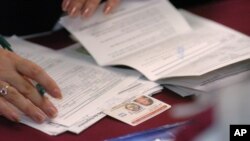 Voluntarios y trabajadores del consulado ayudan a los salvadoreños a renovar la documentación del Estatus de Protección Temporal (TPS) en una iglesia en la sección Van Nuys de Los Ángeles, California, 12 de febrero de 2005.