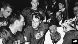 FILE - Detroit Red Wings star forward Gordie Howe is surrounded by teammates as he kneels after scoring his 544th goal to tie the National Hockey League all-time record, in Detroit, Oct. 27, 1963.