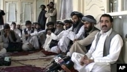 Kandahar provincial governor Ahmad Wali Karzai (R), a brother of Afghan President Hamid Karzai, talks to journalists in Kandahar in this still image taken from a April 2009 video.
