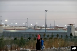 FILE - A woman and a boy walk outside a high security prison complex in Silivri, about 80 kilometers (50 miles) west of Istanbul, Aug. 17, 2016. Turkey abolished the death penalty in 2004 as part of its bid to join the European Union. Reinstating it would deal a fatal blow to its EU ambitions.
